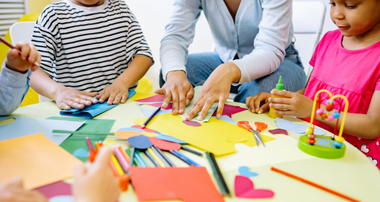 Children and teacher doing arts and crafts with colorful paper and supplies.