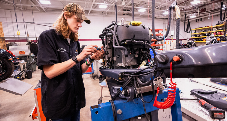 man performing mechanical work on a motorcycle