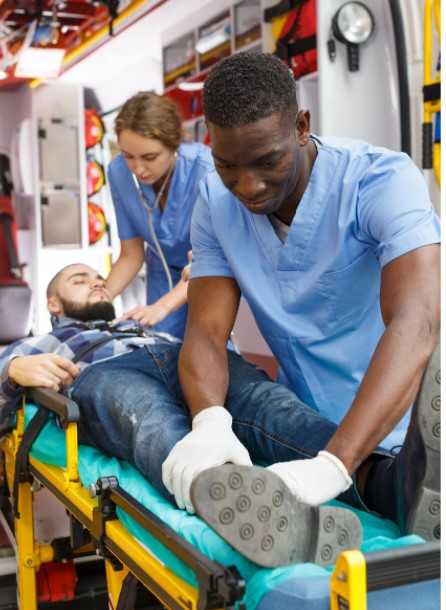 two healthcare employees working on patient exiting ambulence
