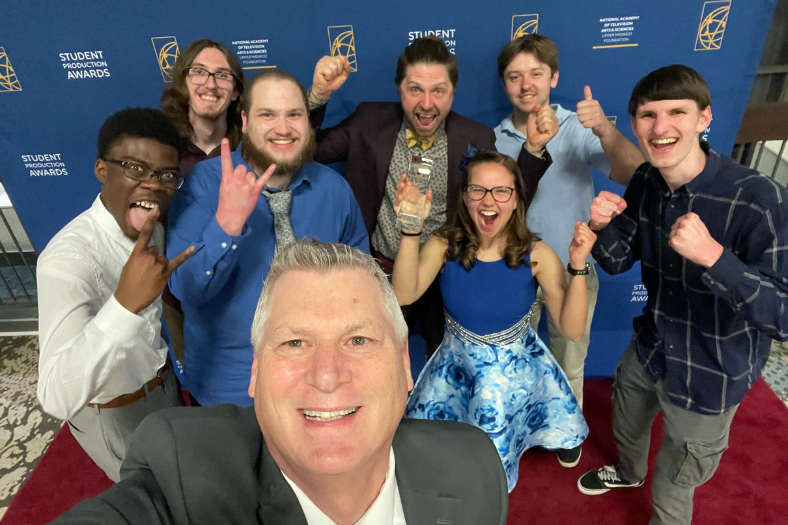 IDVP students gather with faculty Rich Oxley to display a Crystal Pillar Award. 