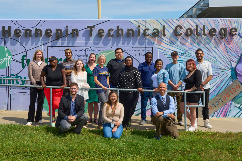 Hennepin Tech students and staff gathered in front of the the campus mural.
