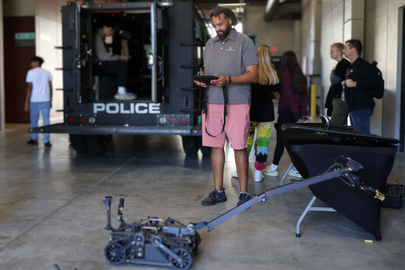 Man with robot near police armored vehicle